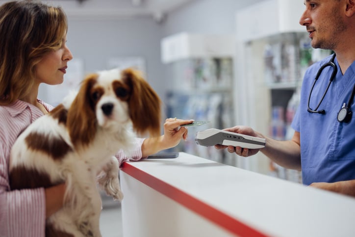 Woman Paying with Credit Card at Veterinary Clinic
