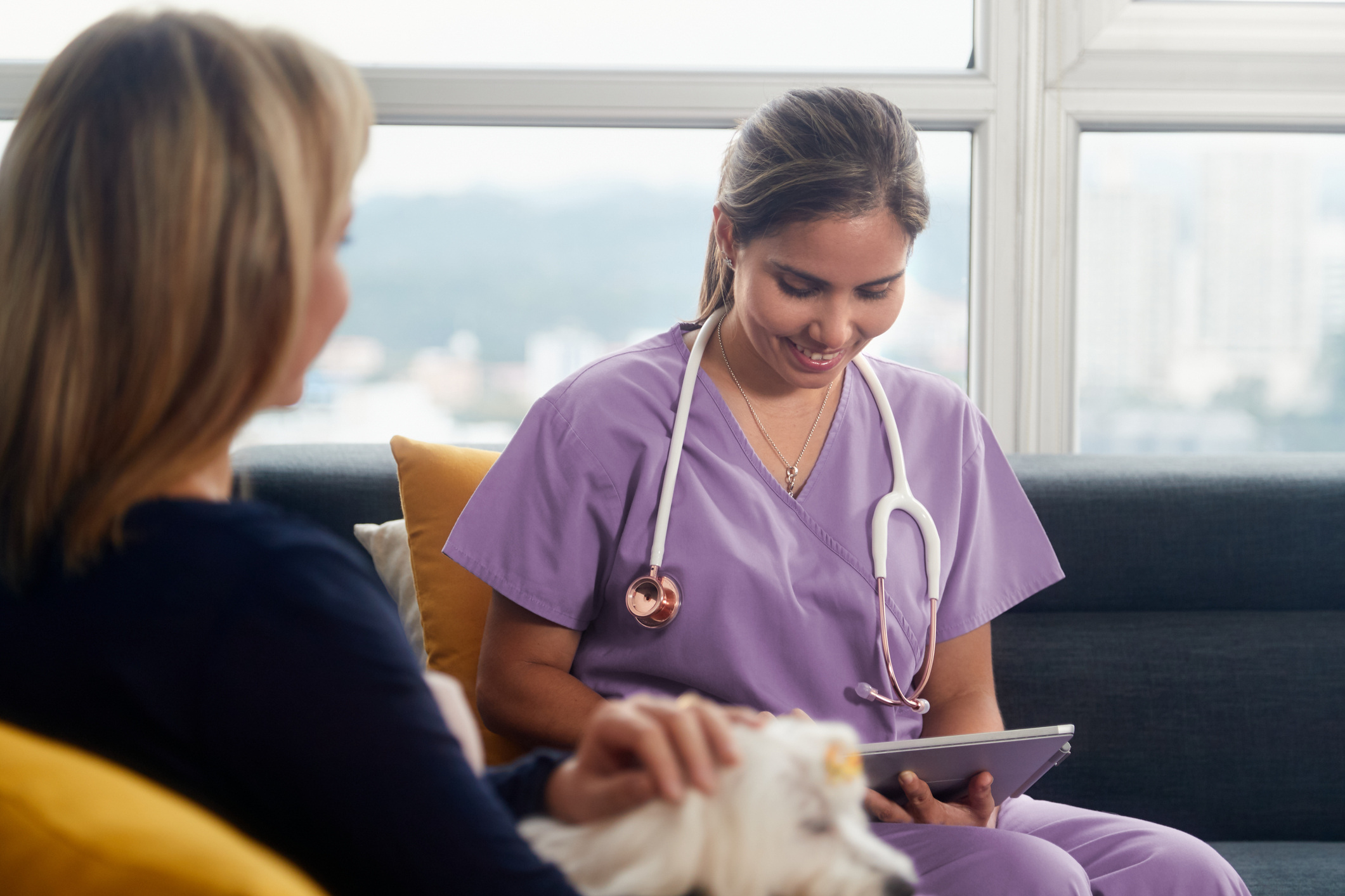 Veterinarian sits with pet owner and her dog