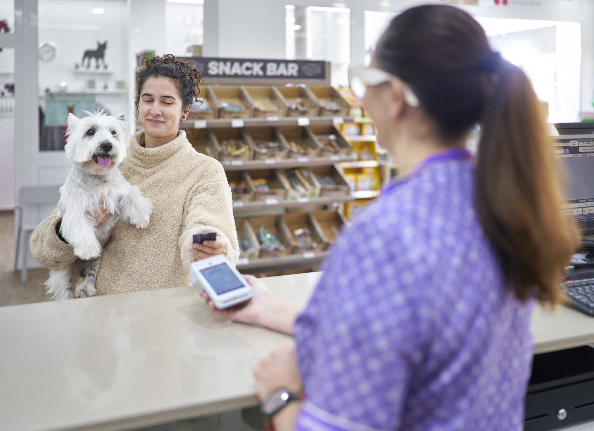 pet-owner-with-puppy-pays-at-counter